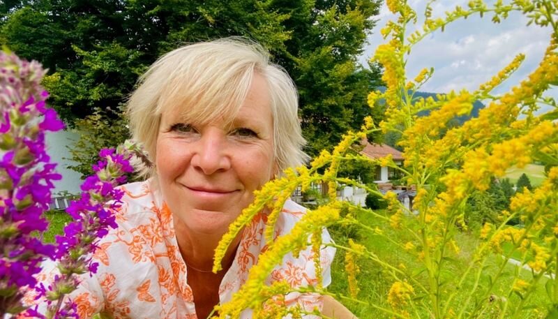 Frau umgeben von bunten Blumen