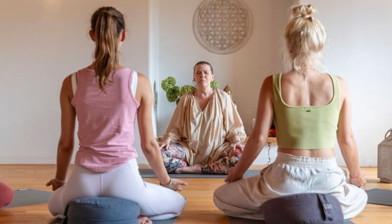Yoga-Kurs mit meditierenden Teilnehmern