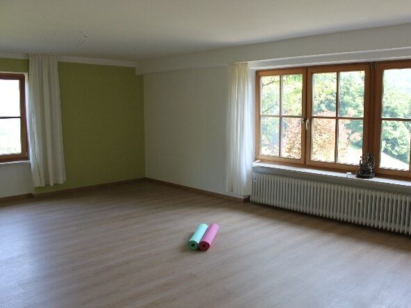 Heller Raum mit Yogamatten und Fenstern