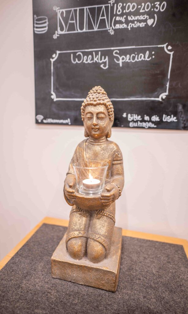 Buddha mit Kerze in der Hand