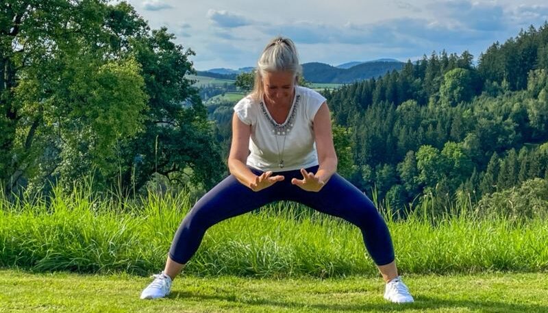 Frau praktiziert Qigong im Freien.