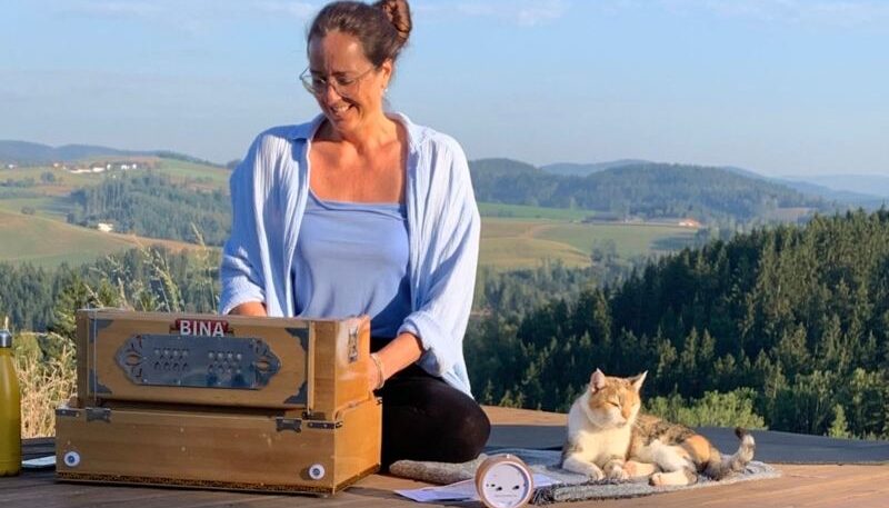 Frau mit Katze und Harmonium draußen