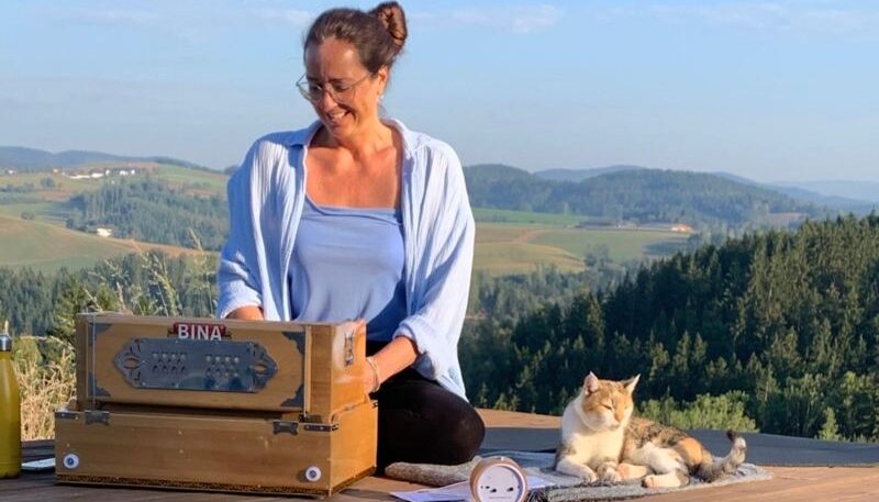 Frau mit Katze und Harmonium draußen