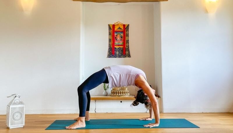 Frau macht Yoga in einem Raum.