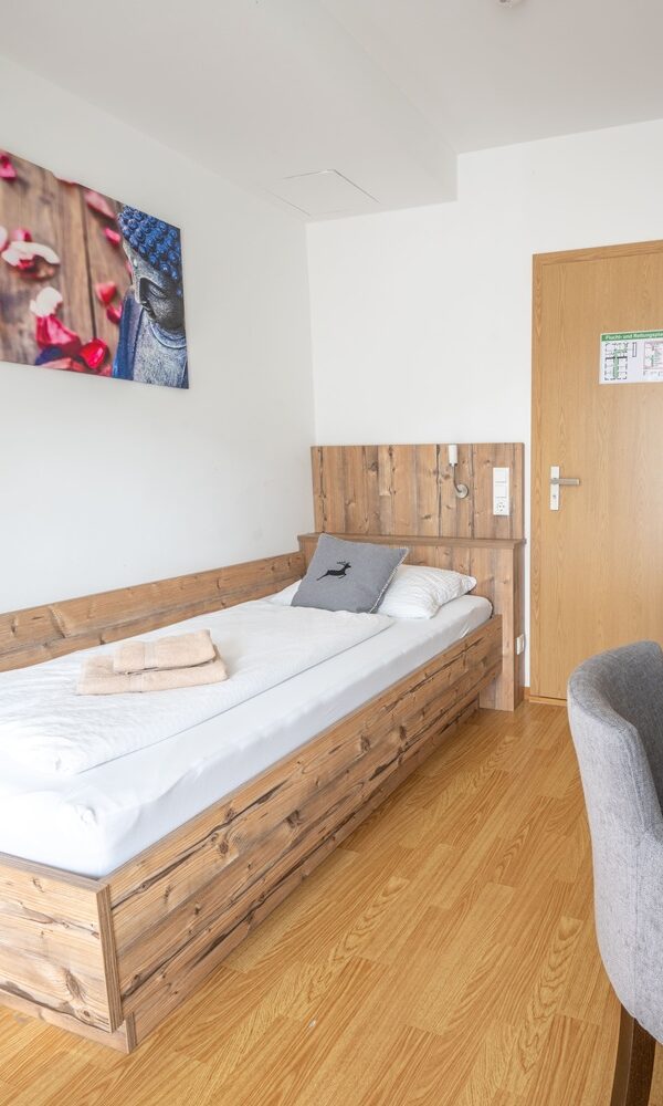 Helles, modernes Einzelzimmer mit Holzdekor.
