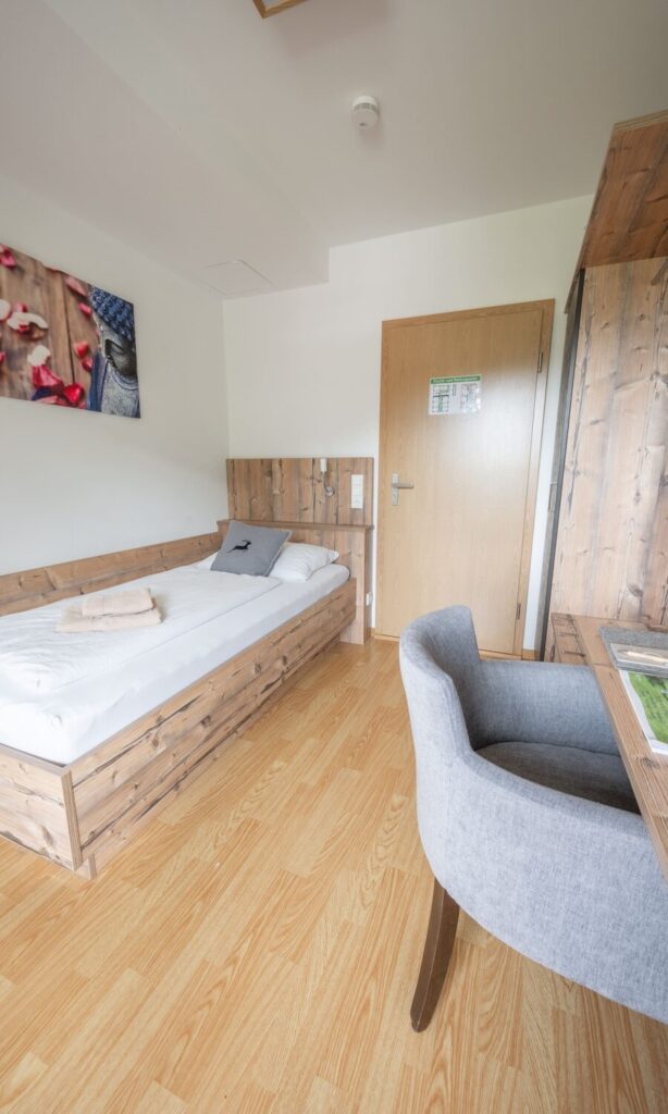 Helles, modernes Einzelzimmer mit Holzdekor.