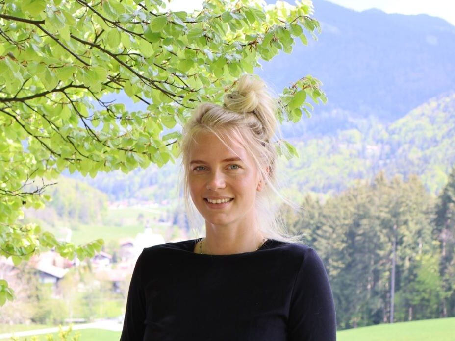 Junge Frau vor grüner Landschaft