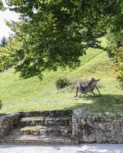 Mann sitzt im Liegestuhl in der Wiese