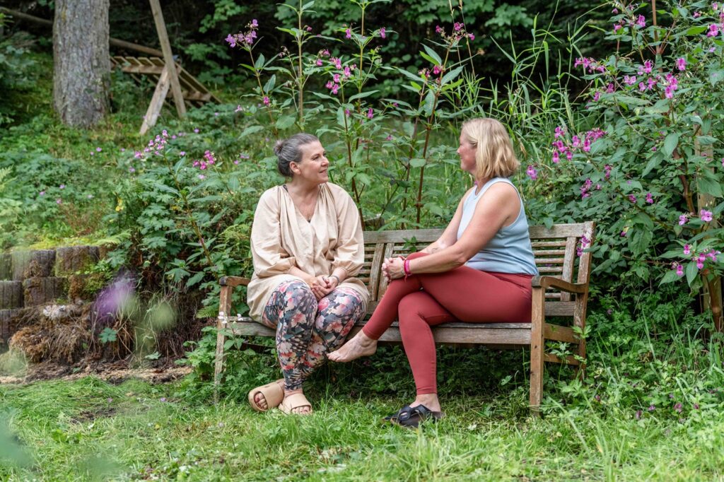 Gäste sitzen im Garten des Mountain Retreat Center im Gespräch
