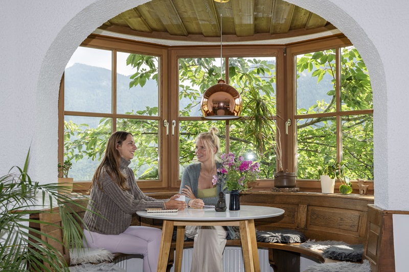 2 frauen sitzen drinnen und unterhalten sich