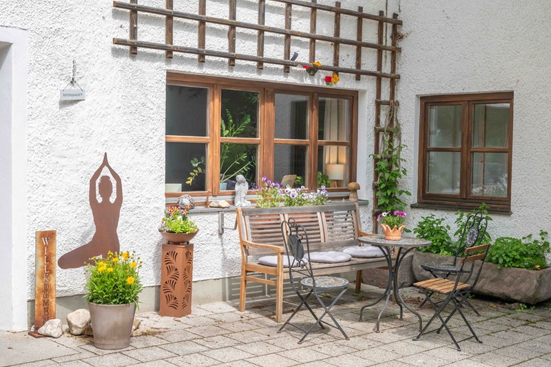 outdoor sitzplatz mit tisch, bank, sesseln und deko