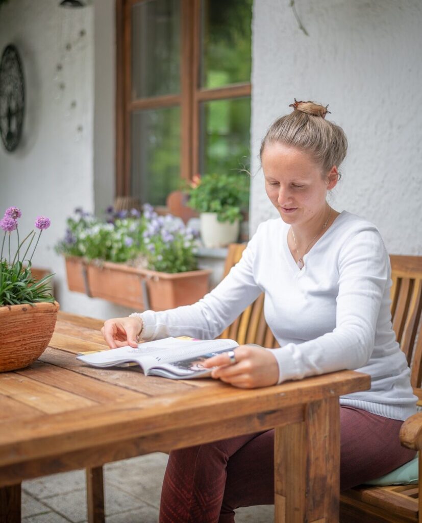 Frau schreibt achtsam an einem Tisch
