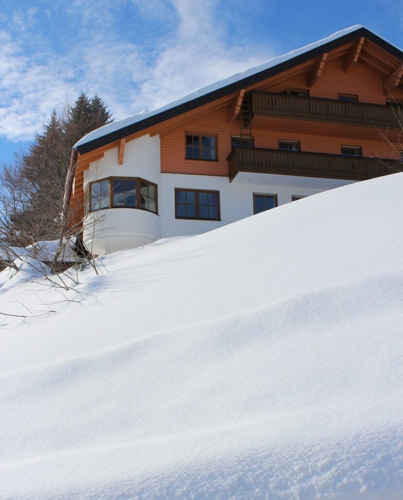 Haus im Schnee unter blauem Himmel