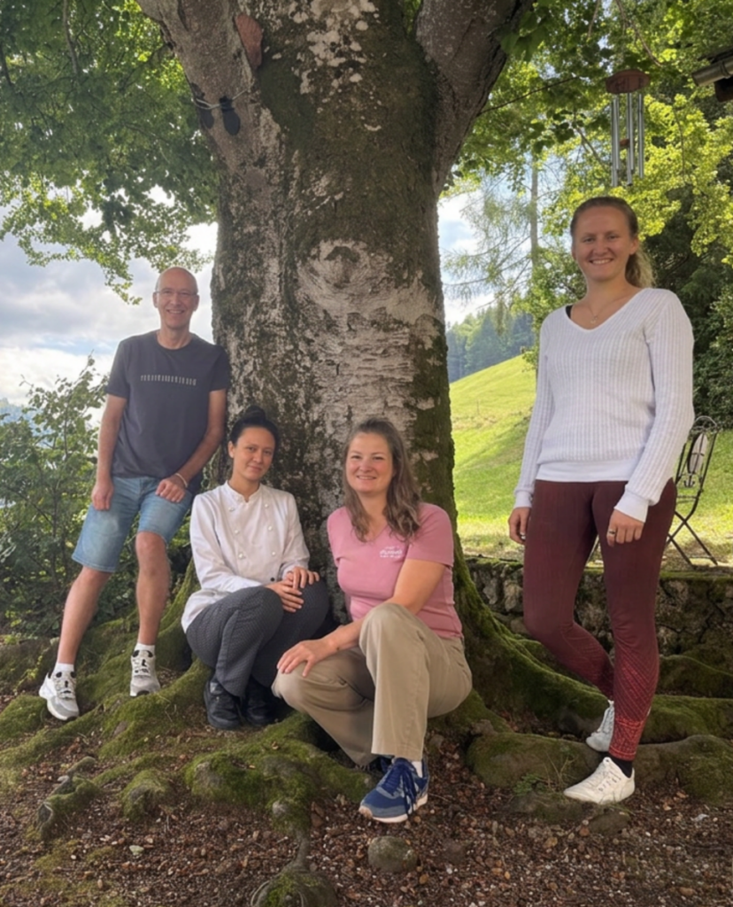 Vier Personen vor einem Baum.