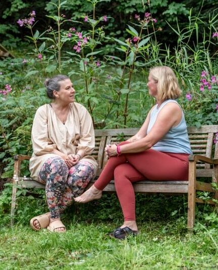 2 frauen im gespräch auf einer gartenbank